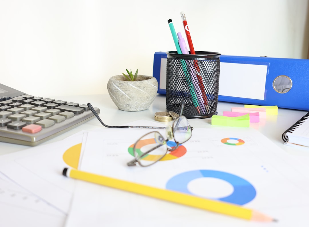 desk-with-calculator-glasses-charts-and-office-supplies-n3xhfnlpdem